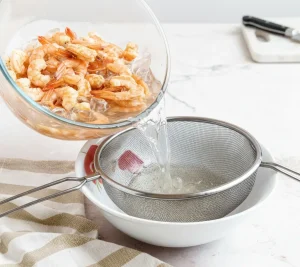 Drain and peel shrimp